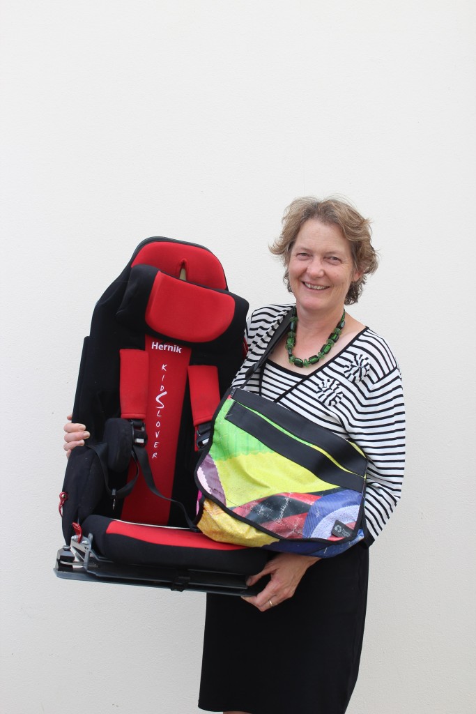 Timaru District Council Waste Minimisation Manager Ruth Clarke with the first child car seat from the area to be recycled as part of the SeatSmart programme. She is also holding a bag made using straps from recycled seats. PHOTO: SUPPLIED/TIMARU DISTRICT COUNCIL